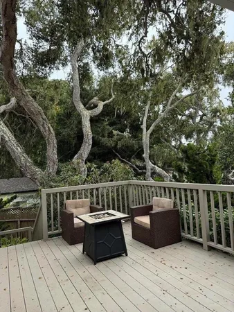 a view of a deck with couches wooden floor and fence