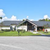 a front view of a house with a garden and plants
