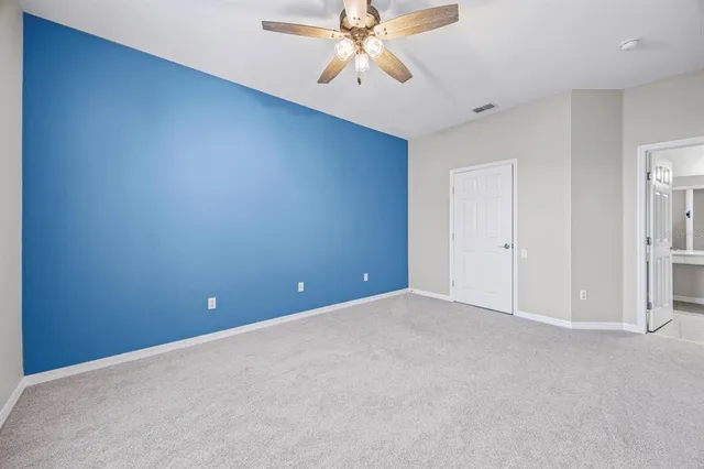 an empty room with chandelier fan