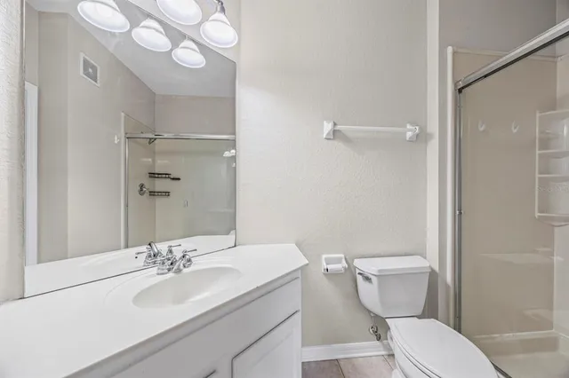 a bathroom with a sink vanity granite toilet and a mirror