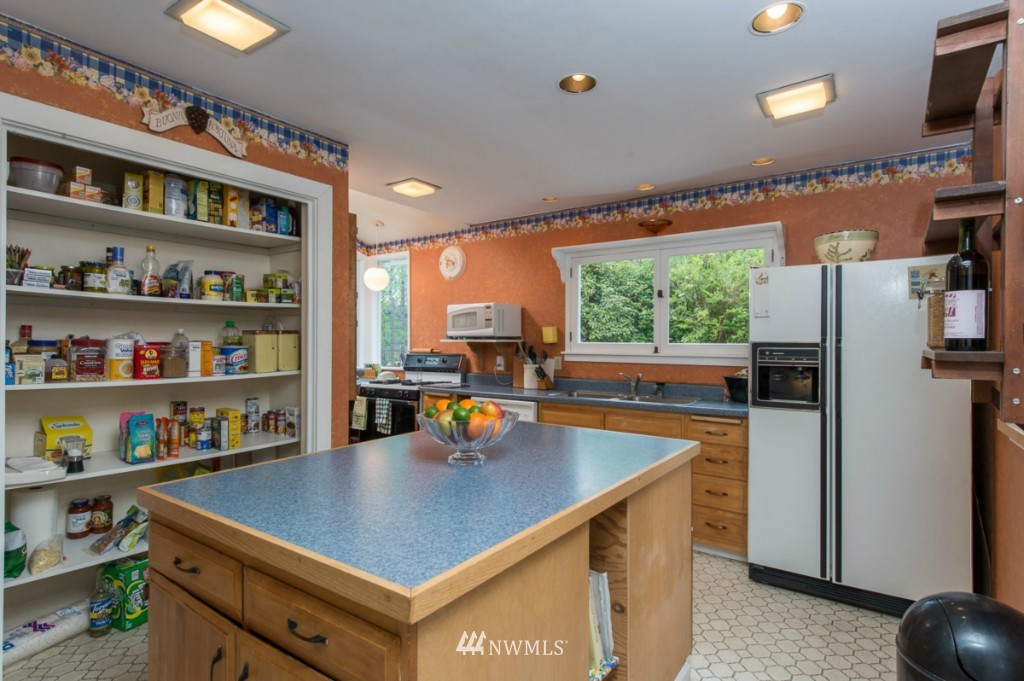 18624 Beall Road Southwest Vashon, WA 98070 - Photo 11 of 25 a kitchen with a refrigerator a stove and a dining table