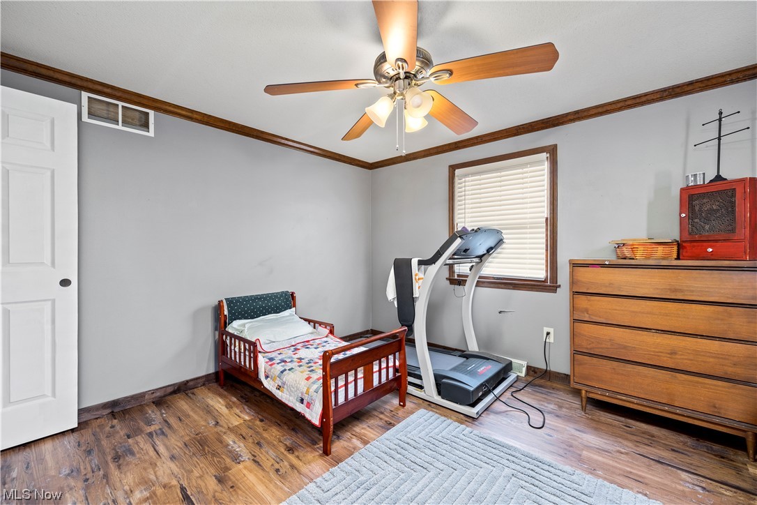 41511 Russia Road Elyria, OH 44035 - Photo 22 of 33 Bedroom with ornamental molding, ceiling fan, and dark hardwood / wood-style floors