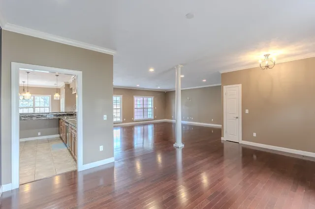 an empty room with wooden floor and a bathroom