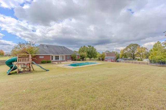 a view of an house with swimming pool and yard