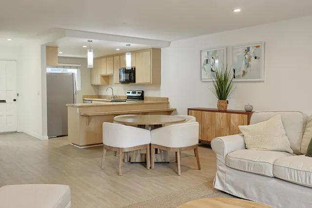 a living room with furniture and a dining table with kitchen view