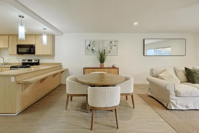 a kitchen with stainless steel appliances a table and chairs in it