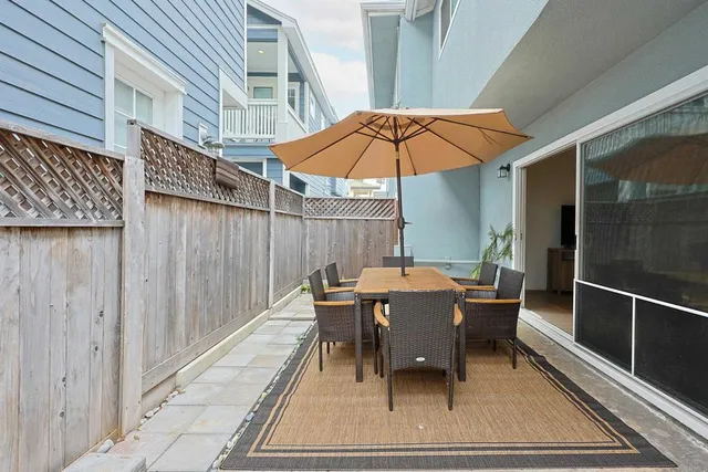 a view of a patio with a table and chairs under an umbrella