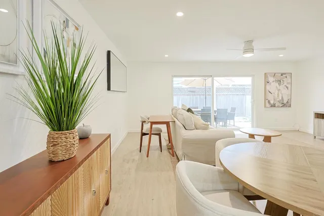 a living room with furniture potted plant and a large window