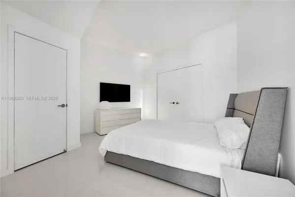 a bedroom with a bed tv and a couch