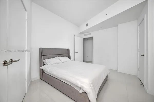 a large white bed in a white room