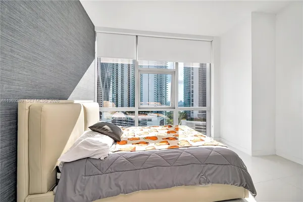 a bed sitting in a bedroom next to a window