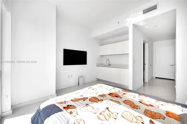 a bedroom with a bed and a flat screen tv