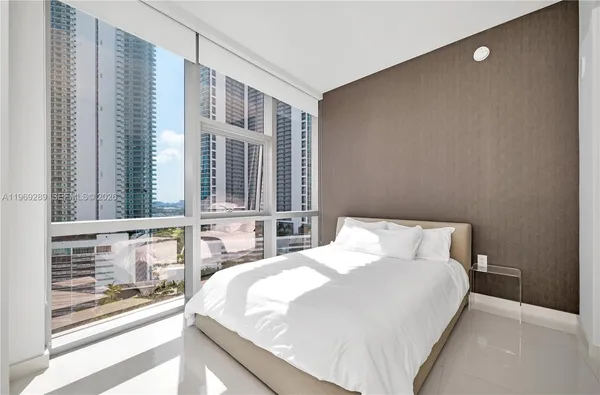 a bedroom with a large bed and a large window