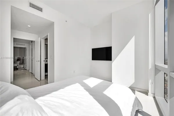 a bedroom with a bed and a flat screen tv