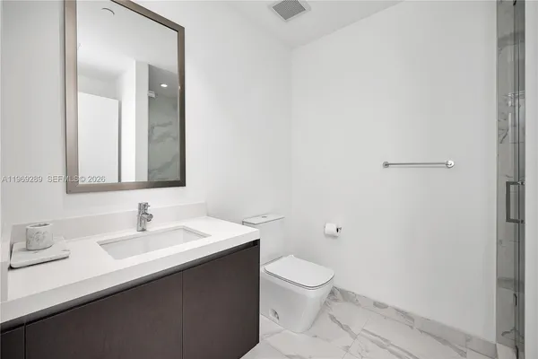 a bathroom with a sink a toilet and a mirror
