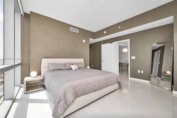 a bedroom with a large bed and a chandelier