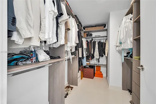 a view of walk in closet with clothes and shoes