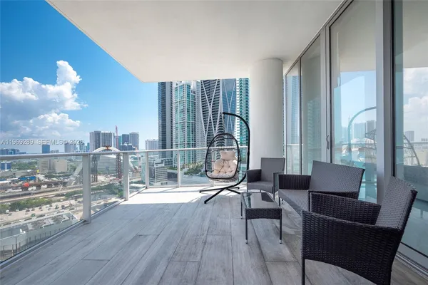 a living room with furniture a large window and wooden floor