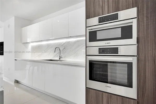 a kitchen with stainless steel appliances white cabinets and a stove