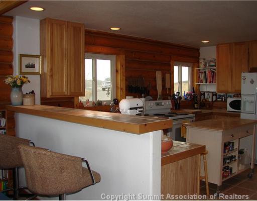 317 Sheep Ridge Road Fairplay, CO 80440 - Photo 2 of 12 a view of a kitchen with kitchen island granite countertop a sink cabinets and wooden floor