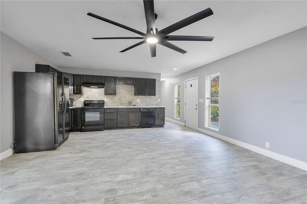 704 Grape Avenue St. Cloud, FL 34769 - Photo 15 of 30 a large kitchen with stainless steel appliances a refrigerator and a sink
