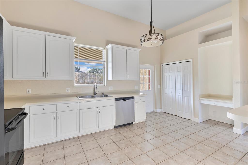 704 Grape Avenue St. Cloud, FL 34769 - Photo 5 of 30 a kitchen with a sink refrigerator and cabinets