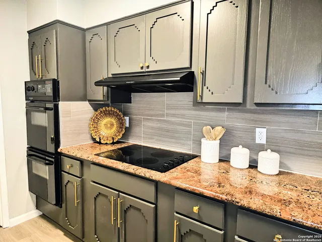 a kitchen with granite countertop a sink and cabinets