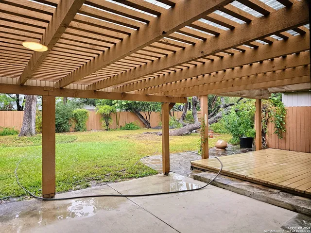 a view of a patio with table and chairs under an umbrella next to a yard