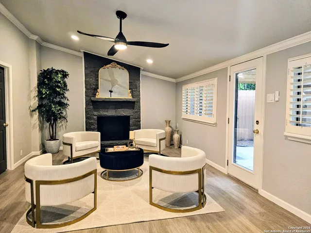 a living room with furniture a fireplace and a potted plant