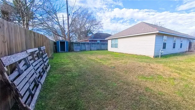 a view of a backyard with wooden fence