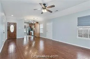 a view of an empty room with window and wooden floor