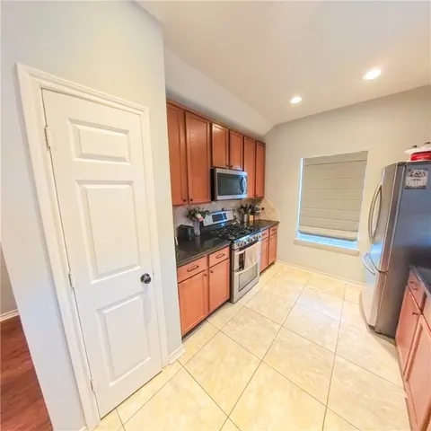 a kitchen with stainless steel appliances a refrigerator and a stove top oven