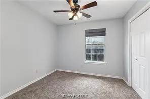 an empty room with a window and a fan