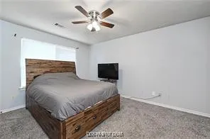 a bedroom with a bed and a ceiling fan