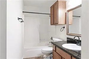 a bathroom with a granite countertop sink toilet and shower