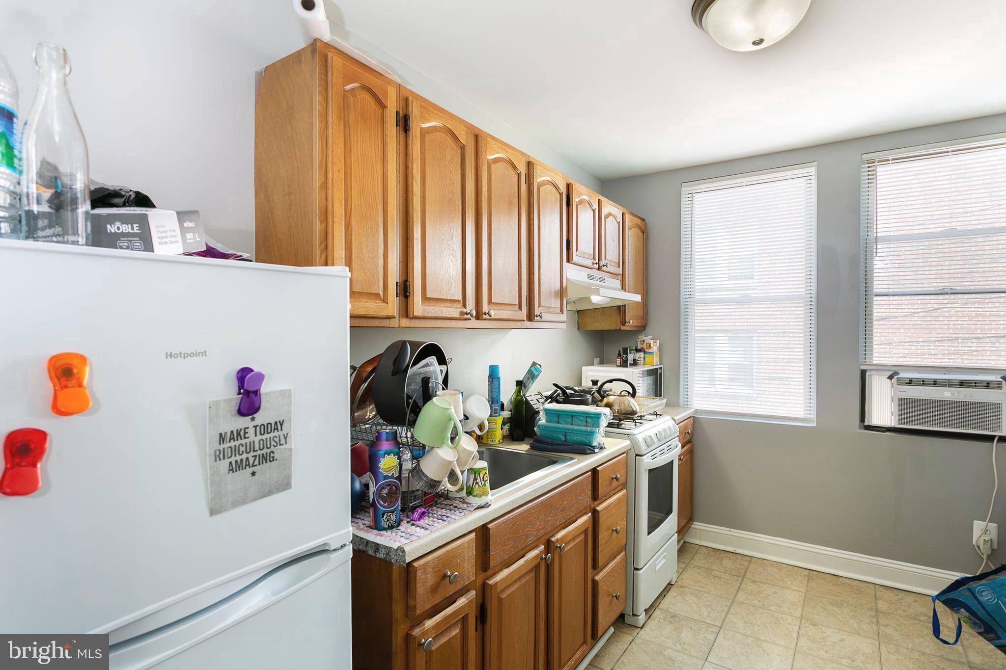2736 East Preston Street Baltimore, MD 21213 - Photo 3 of 15 a kitchen with stainless steel appliances a sink a refrigerator and a window