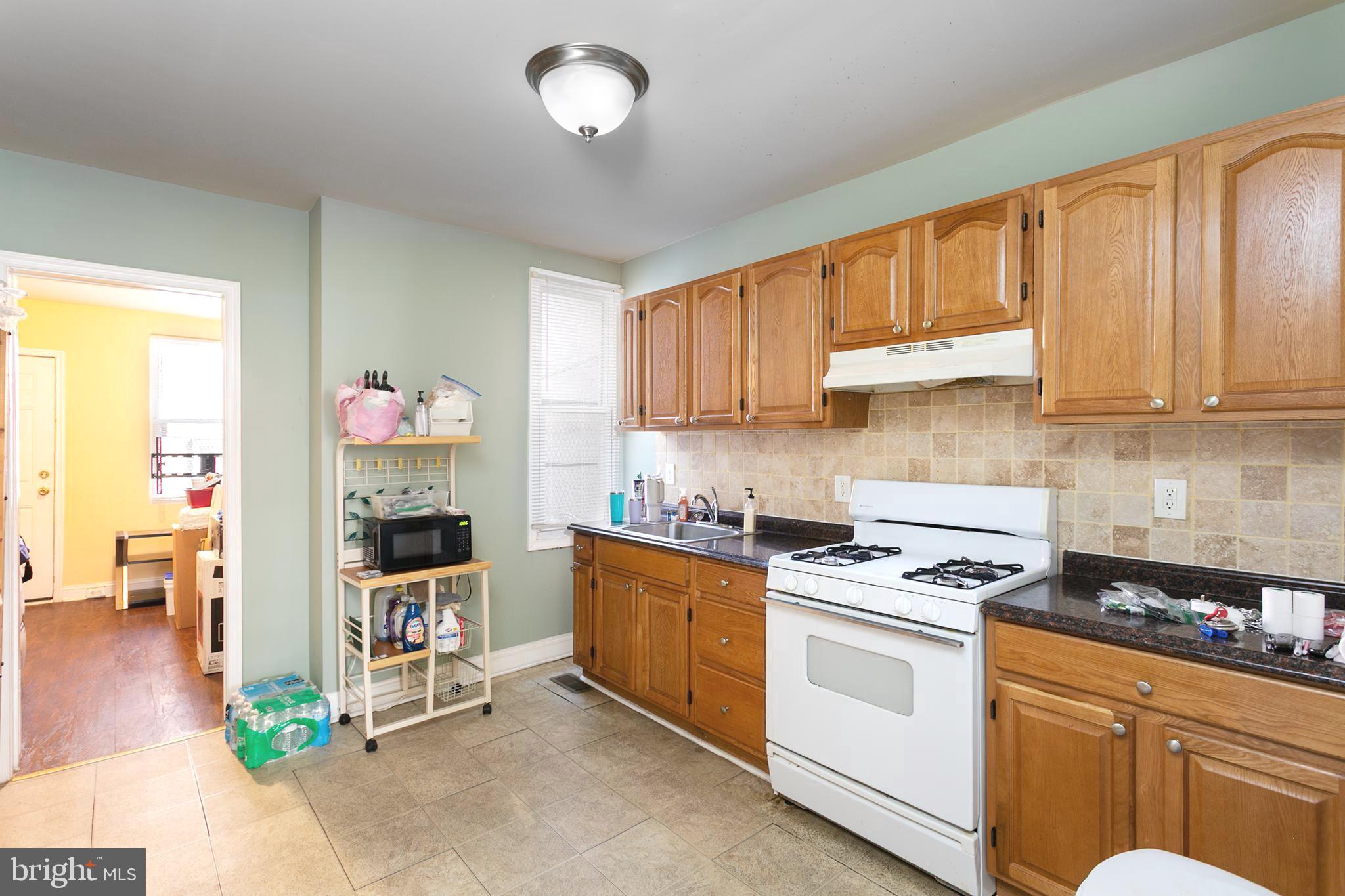 2736 East Preston Street Baltimore, MD 21213 - Photo 7 of 15 a kitchen with stainless steel appliances granite countertop a stove a sink and a microwave