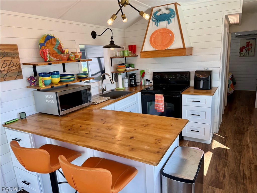 19681 Summerlin Road, Unit 482 Fort Myers, FL 33908 - Photo 2 of 35 an open kitchen with wooden floor and breakfast area