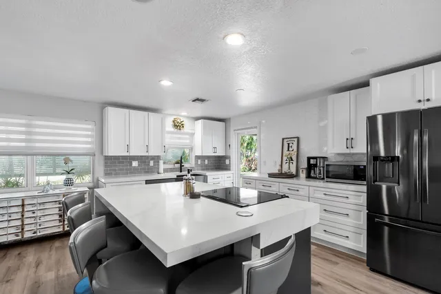 a kitchen with stainless steel appliances kitchen island granite countertop a sink and cabinets