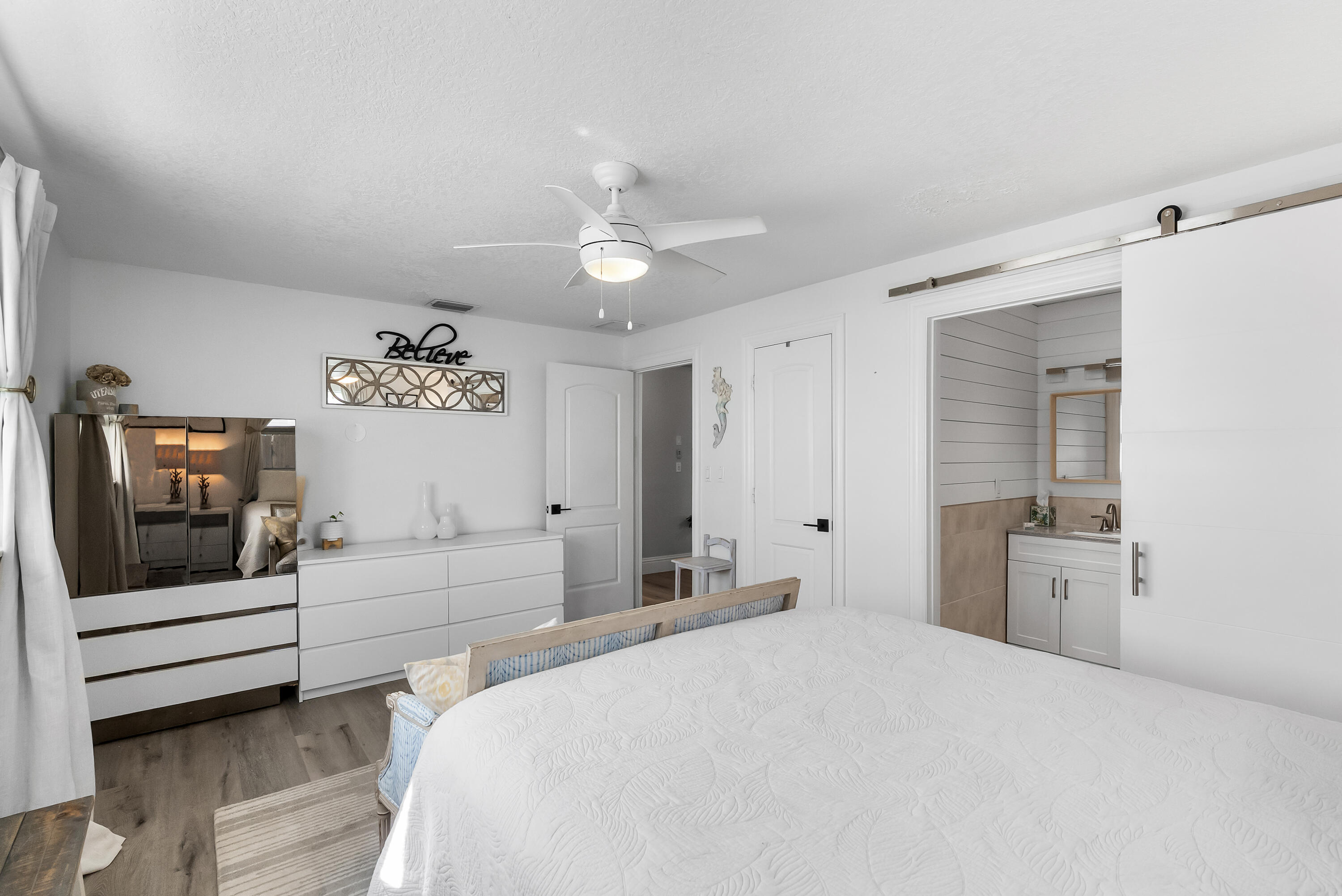 1605 Treemont Avenue Jupiter, FL 33469 - Photo 24 of 35 a bedroom with a bed and a chandelier