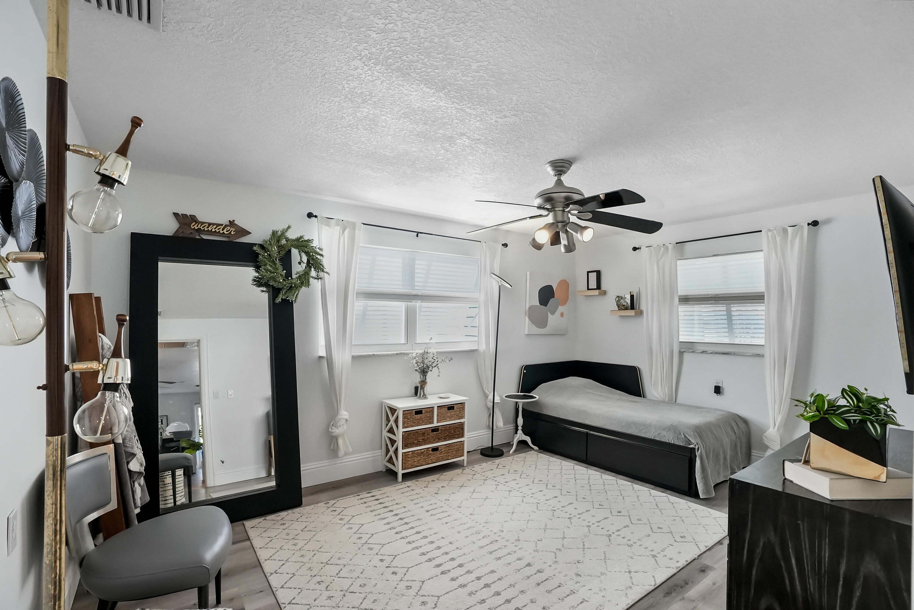 1605 Treemont Avenue Jupiter, FL 33469 - Photo 27 of 35 a bedroom with furniture and a chandelier