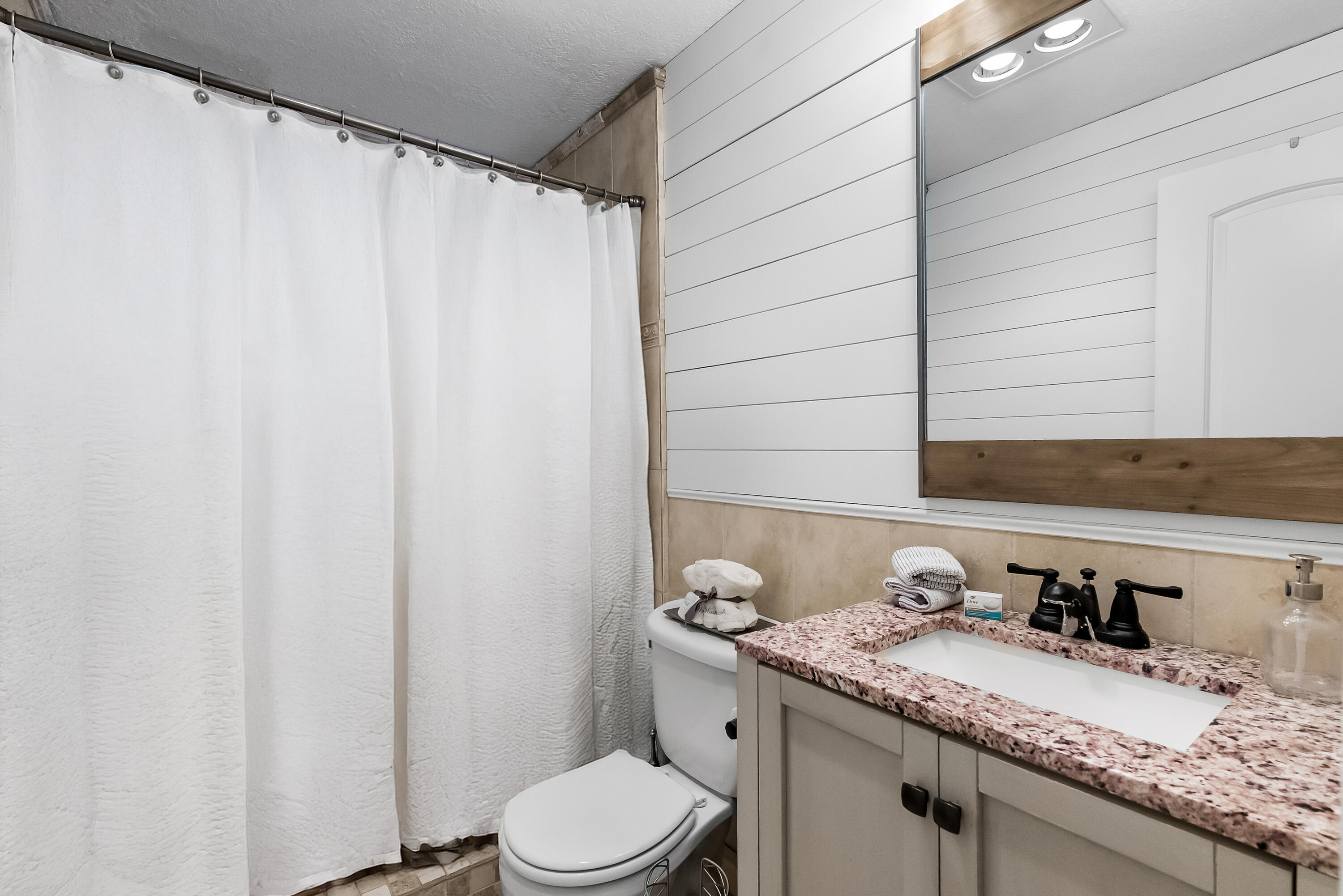 1605 Treemont Avenue Jupiter, FL 33469 - Photo 28 of 35 a bathroom with a granite countertop sink and a mirror
