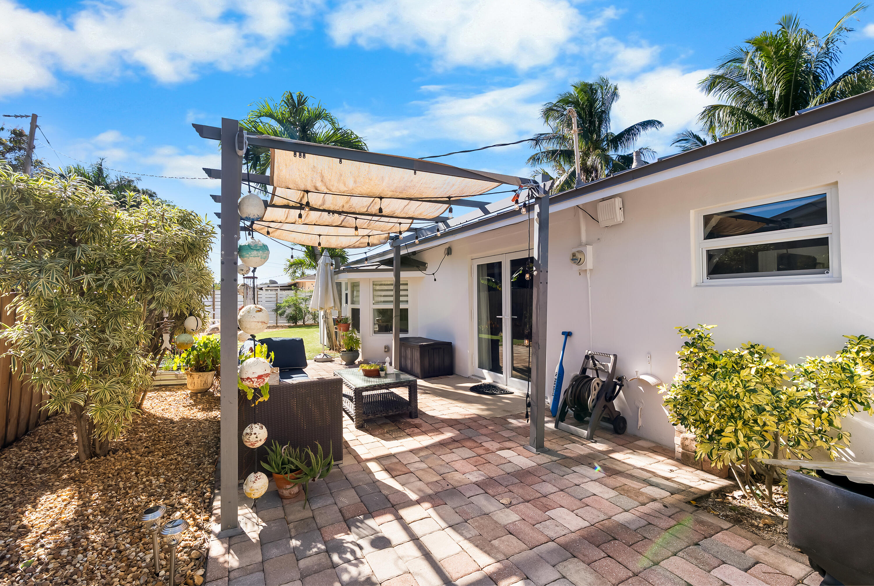 1605 Treemont Avenue Jupiter, FL 33469 - Photo 32 of 35 a view of a patio with table and chairs potted plants
