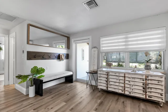 a living room with furniture kitchen view and a large window