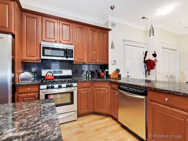 1453 West Irving Park Road, Unit 304 Chicago, IL 60613 - Photo 6 of 17 a kitchen with stainless steel appliances granite countertop a stove sink and cabinets