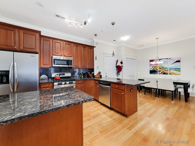 1453 West Irving Park Road, Unit 304 Chicago, IL 60613 - Photo 7 of 17 a large kitchen with a large counter top appliances and cabinets