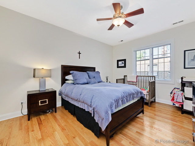 1453 West Irving Park Road, Unit 304 Chicago, IL 60613 - Photo 10 of 17 a spacious bedroom with a bed and a ceiling fan
