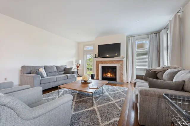 a living room with furniture a flat screen tv and a fireplace