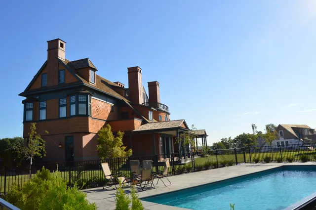 a front view of a house with swimming pool having outdoor seating
