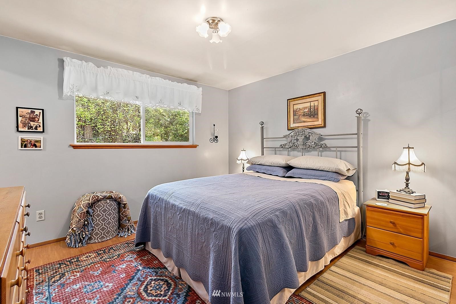 509 Roe Street Steilacoom, WA 98388 - Photo 14 of 40 a bedroom with a bed and a lamp on dresser